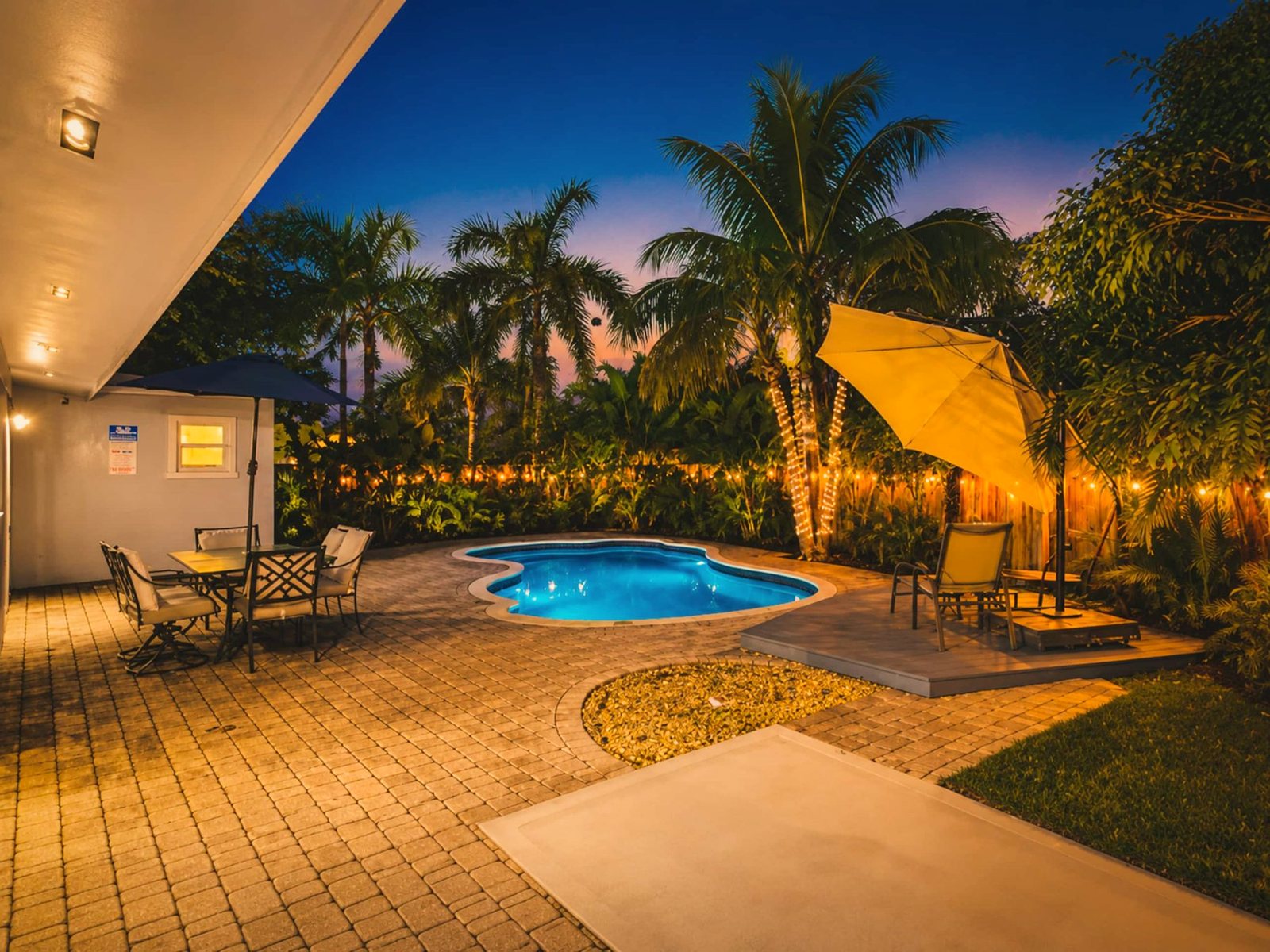 Heated pool and patio at twilight at a home BookedMore co-hosts in Fort Lauderdale, Florida
