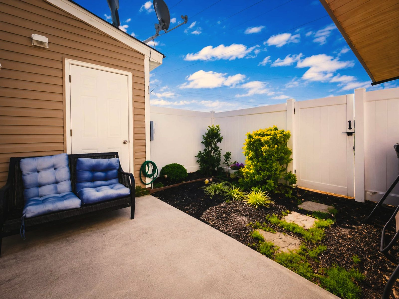Fenced backyard patio with cushioned seating at Hickswood Townhome in High Point, North Carolina