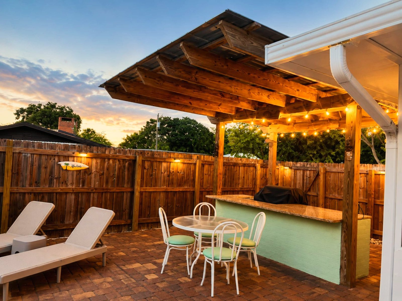 Covered pergola with an outdoor bar and seating beside the pool at Space Coast Pool Haven in Melbourne, Florida