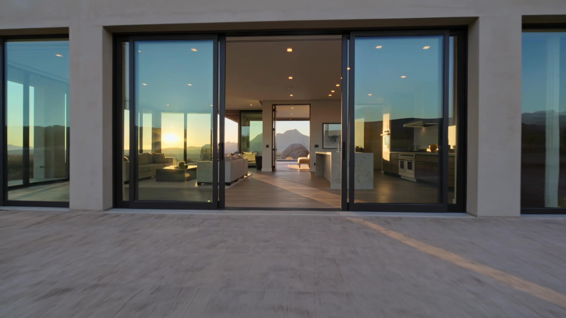 Video walk-through of a modern desert home at sunset, from the patio into the living room and kitchen
